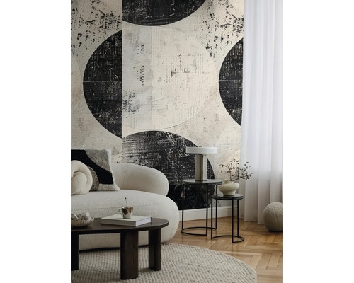 Vardagsrum med soffa, soffbord och tapet med abstrakt cirkelmönster.