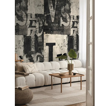 Vardagsrum med soffa, träbord och tapet med tidningsdesign