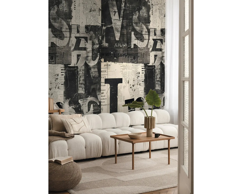 Vardagsrum med soffa, träbord och tapet med tidningsdesign