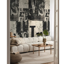 Vardagsrum med soffa, träbord, matta och tapet med tidningsmönster