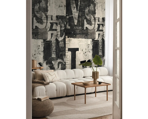 Vardagsrum med soffa, träbord, matta och tapet med tidningsmönster