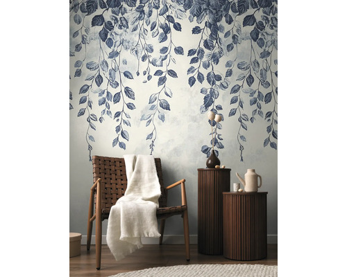 Dekorativ tapet med bladmönster i ett stilfullt vardagsrum med fåtölj och sidobord.