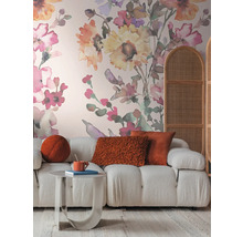 Vardagsrum med soffa, bord, kuddar och blomstertapet för en mysig atmosfär