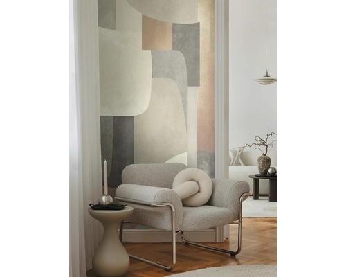 Vardagsrum med fåtölj, sidobord och geometrisk tapet