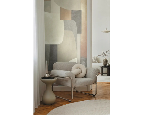 Vardagsrum med fåtölj, sidobord och abstrakt väggkonst för en stilren inredning