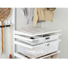 Detaljbild av ett skåpsystem med hyllor och trådkorgar för förvaring