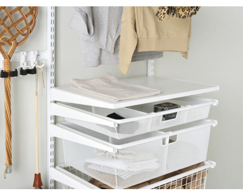 Detaljbild av ett skåpsystem med hyllor och trådkorgar för förvaring