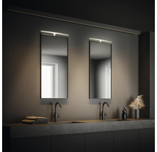 Modernt badrum med två handfat, speglar och belysning