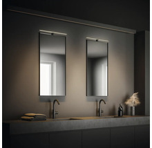 Badrum med två handfat, speglar med belysning och förvaringsutrymme