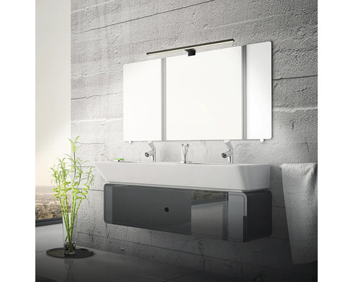 Badrum med tvättställ, spegel och belysning