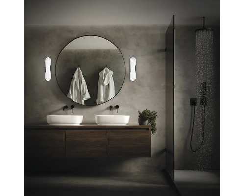 Modernt badrum med dubbla handfat, rund spegel och dusch