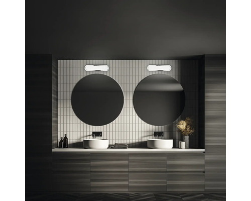 Badrum med dubbla handfat, runda speglar och vägglampor