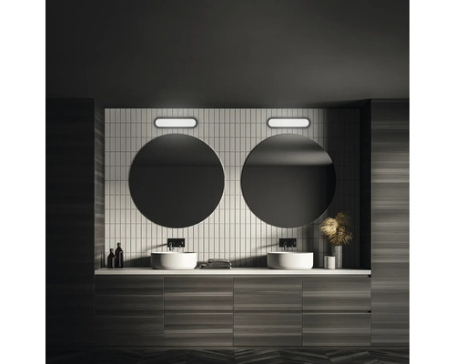 Modernt badrum med dubbla handfat, runda speglar och träpanel