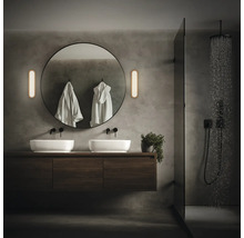 Modernt badrum med dubbla handfat, rund spegel och dusch