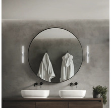 Modernt badrum med dubbla handfat, rund spegel och vägglampor