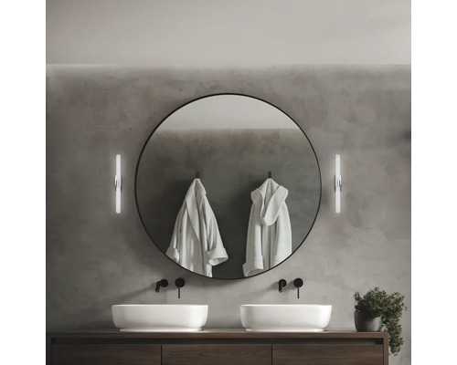 Modernt badrum med dubbla handfat, rund spegel och vägglampor