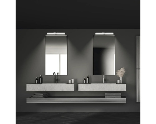 Modernt badrum med två handfat, speglar och förvaringsutrymme för handdukar