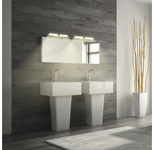 Modernt badrum med dubbla handfat, spegel och belysning mot en trävägg