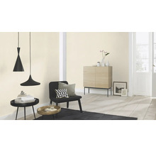 Ljust rum med två hänglampor, stol, byrå och dekorationer