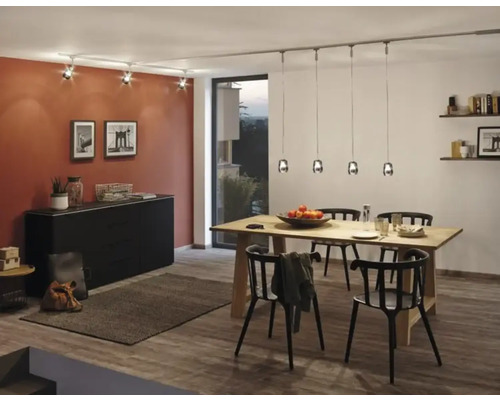 Matsal med träbord, svarta stolar, byrå och belysningssystem