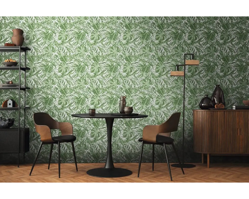Matsal med bord, stolar och hylla mot en grön bladtapet