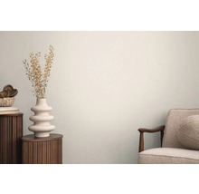 Ljus interiör med sidobord, vas med torkade blommor och fåtölj