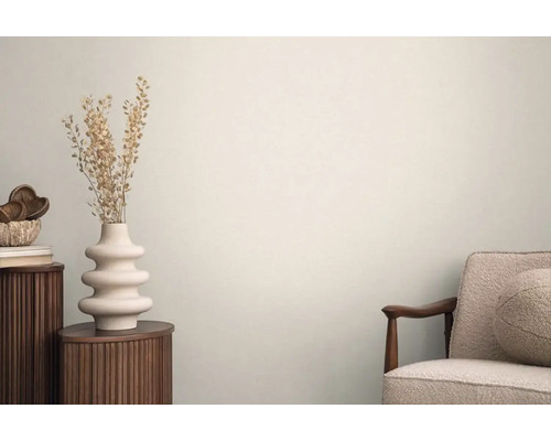 Ljus interiör med sidobord, vas med torkade blommor och fåtölj