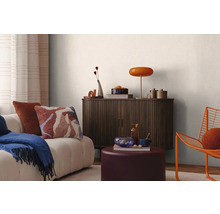 Vardagsrum med soffa, träskåp, lampa och dekoration