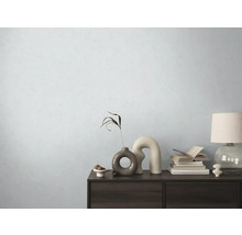 Dekorativ byrå med vaser, böcker och lampa framför en ljus vägg