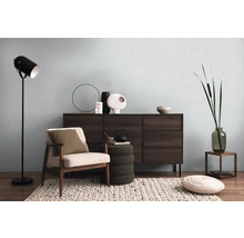 Vardagsrum med byrå, fåtölj, golvlampa och dekorativa element för en mysig atmosfär