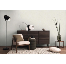 Vardagsrum med fåtölj, byrå, golvlampa och dekoration för en mysig atmosfär.