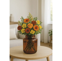 Blombukett med rosor, gerberor och alstroemeria i en glasvas på ett bord