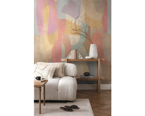 Vardagsrum med soffa, hylla och abstrakt väggdesign för en ljus och organiserad atmosfär.