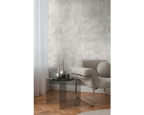 Dekorativt rum med fototapet i betonglook, fåtölj och sidobord