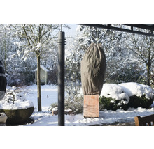Vinterlandskap med växtskyddshölje i trädgården