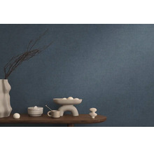 Blå non-woven tapet i vardagsrum med dekoration på ett träbord.