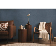 Vardagsrum med soffa, fåtölj, sidobord och dekoration framför en blå vägg