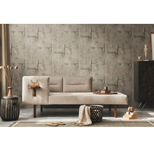 Vardagsrum med beige soffa, mönstrad tapet och dekorativa element för en mysig atmosfär.