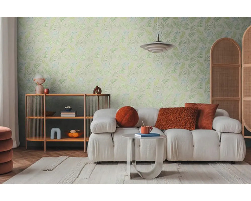 Ljust vardagsrum med soffa, hylla och väggtapet med bladmönster