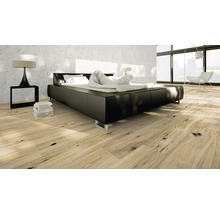 Sovrum med modern säng, sängbord och trägolv.