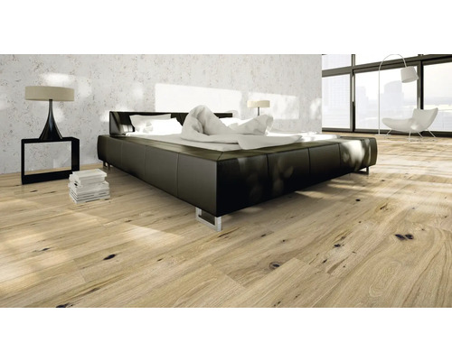 Sovrum med modern säng, sängbord och trägolv.