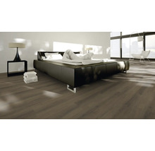 Sovrum med laminatgolv, säng och sänglampa.