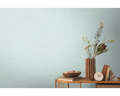 Dekorativt boende med bord, vas, blommor, skål och böcker mot en vägg