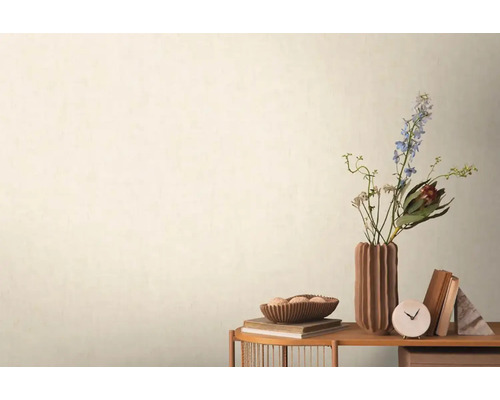 Dekorativ scen med blommor, böcker och bordsklocka på ett sidobord mot en vägg