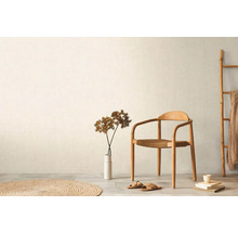 Ljust rum med trästol, dekoration och textilier för en vänlig atmosfär.