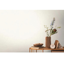 Dekorativ scen med blommor i vas, skål, böcker och klocka på ett bord