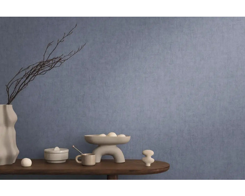 Dekorativt arrangemang på ett bord framför en blå vägg