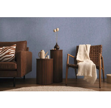 Vardagsrumsscen med soffa, stol och sidobord mot en blå vägg