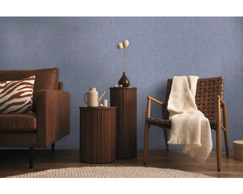 Vardagsrumsscen med soffa, stol och sidobord mot en blå vägg