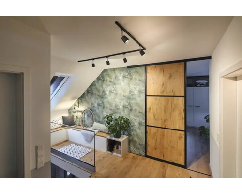 Ljusvindsvåning med takfönster, sittgrupp, grön bladentapet, skjutdörr och trägolv.